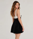The Marilyn Bow Strap Velvet Skater Dress is a mini dress in black, perfect for an above-the-knee holiday party dress or a stylish NYE look, with a short hemline designed to make a winter statement.