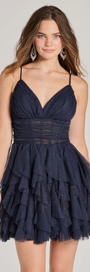 Step into seasonal chic with the Leanna Ruffle Glitter Mesh Skater Dress, a navy mini dress featuring an above-the-knee cut ideal for cocktail parties, festive gatherings, or clubwear.
