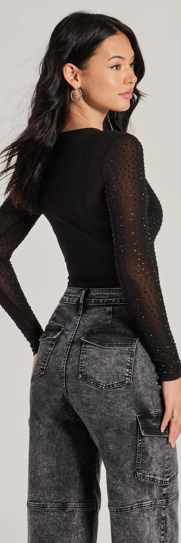 The Feel The Heat Stone Crop Top in black is a sequin top with an all-over sparkle, perfect for creating a glam concert outfit or adding shimmer to a going-out look.