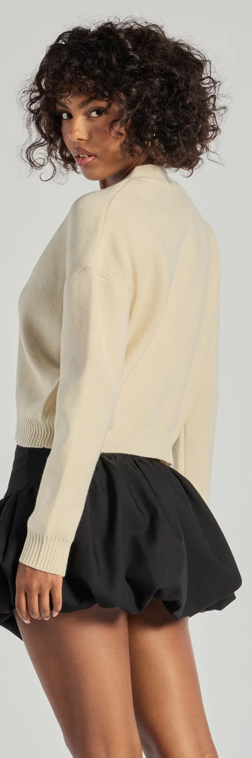 Layer-friendly Floral Charm Cropped Cardigan Knit Sweater is a chic, transitional ivory long-sleeve top with contemporary sleeves and neckline design, ideal for an elevated cozy style or casual elegance.