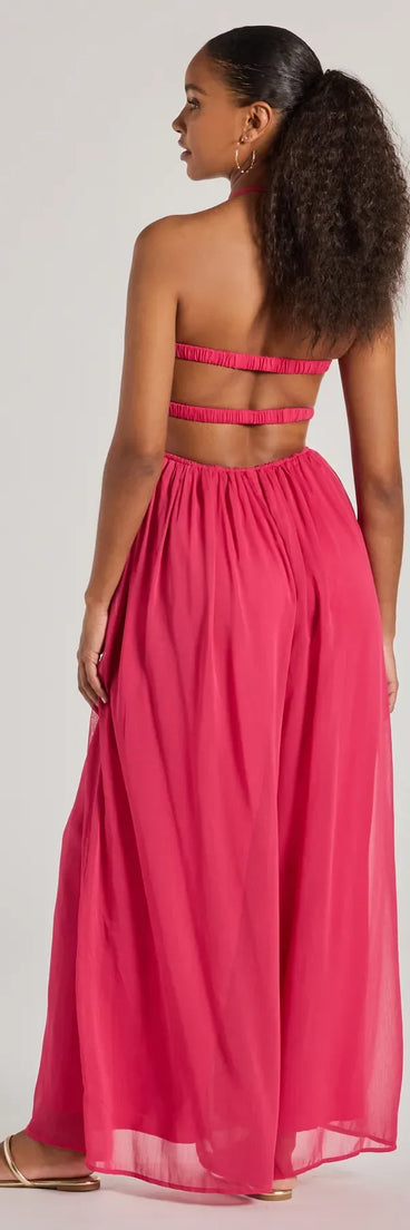The Ready To Charm Halter Cutout Wide-Leg Jumpsuit in fuchsia is a versatile women's jumpsuit with trendy design accents, crafted for holiday-ready looks, from office wear to sophisticated winter night outs.