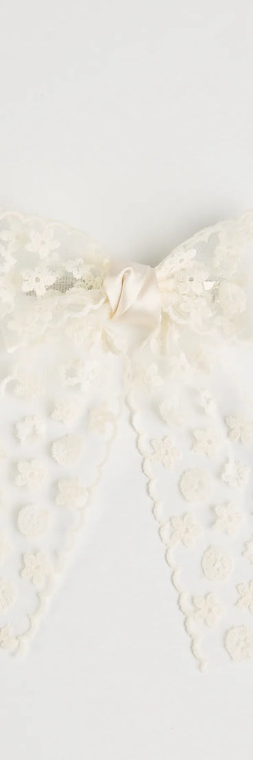 The Poised Attitude Lace Hair Bow Clip in ivory brings sleek style to any graduation outfit, from cap and gown to after-party.