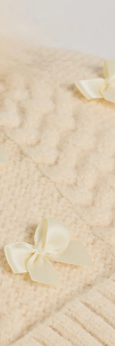 Add a touch of seasonal charm to your winter wardrobe with the Stay Toasty Bow And Pom Knit Beanie, a ivory cold-weather accessory that effortlessly completes your seasonal looks!