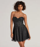 Step into seasonal chic with the Leah Glitter Mesh Corset Skater Dress, a black mini dress featuring an above-the-knee cut ideal for cocktail parties, festive gatherings, or clubwear.