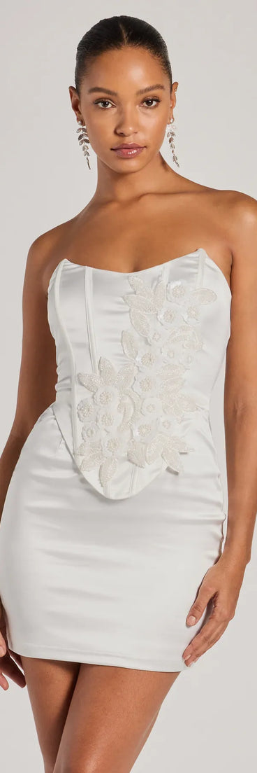 Turn heads in the beaming Hannah Pearl Beaded Floral Satin Corset Mini Dress, a stunning white sequin dress designed to add sparkle and elegance to your next night out or special occasion.