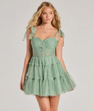 Turn heads at Prom 2025 in this sage green prom dress, where statement-making details meet the iconic style of the Lizzy Ruffled Glitter Mesh Skater Dress .