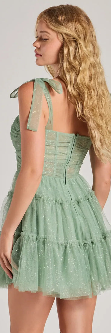 Own every entrance in the Lizzy Ruffled Glitter Mesh Skater Dress, a sage green party dress perfect for milestone birthdays and grad parties, or dancing through autumn nights and unforgettable bachelorette celebrations.