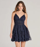 Step into seasonal chic with the Leanna Ruffle Glitter Mesh Skater Dress, a navy mini dress featuring an above-the-knee cut ideal for cocktail parties, festive gatherings, or clubwear.