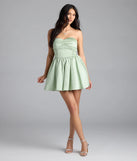 Step into summer looking effortlessly chic in the Lorena Satin Strapless Skater Dress in sage green, a must-have Windsor dress for your warm-weather wardrobe.