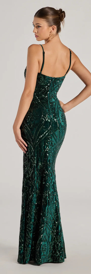 The Lilia Sequin Velvet High Slit Column Dress in hunter is a stunning green prom dress designed to capture attention with its fresh or bold color and effortlessly stylish silhouette.
