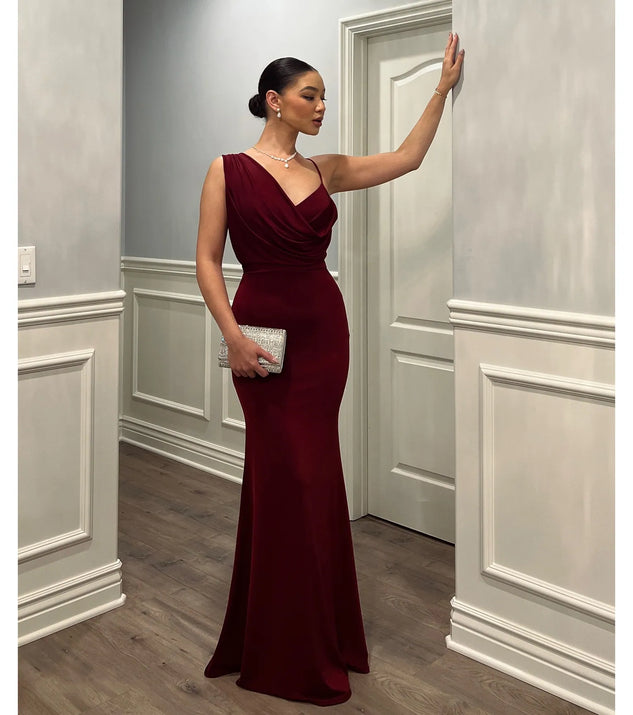 Turn heads at Prom 2025 in this wine prom dress, where statement-making details meet the iconic style of the Margot One-Shoulder Cowl Neck Mermaid Dress .