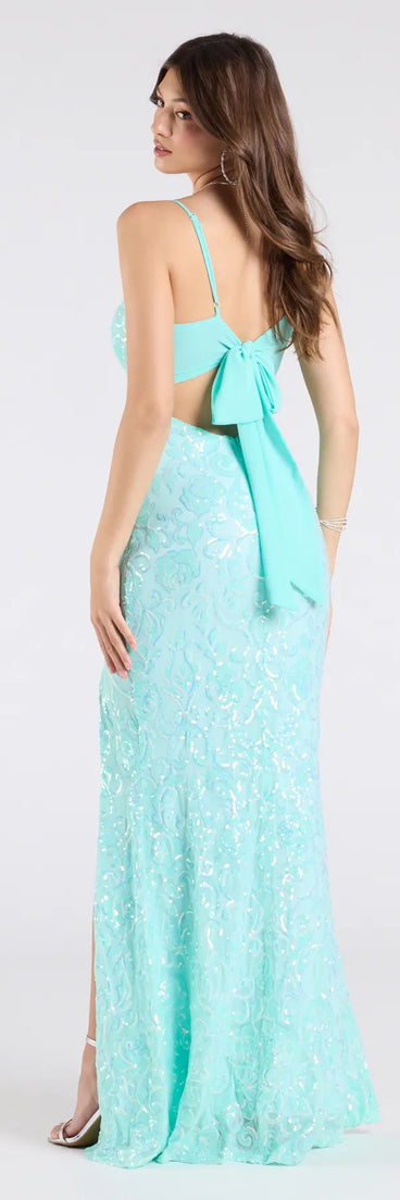 The Dana Tie Back Slit Sequin Formal Dress in mint is a stunning green prom dress designed to capture attention with its fresh or bold color and effortlessly stylish silhouette.