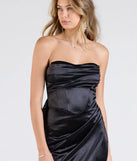 The Mackenzie Strapless Corset Bow Satin Formal Dress is a show-stopping black prom dress, offering a sleek, slimming silhouette that enhances your natural beauty for an unforgettable night.