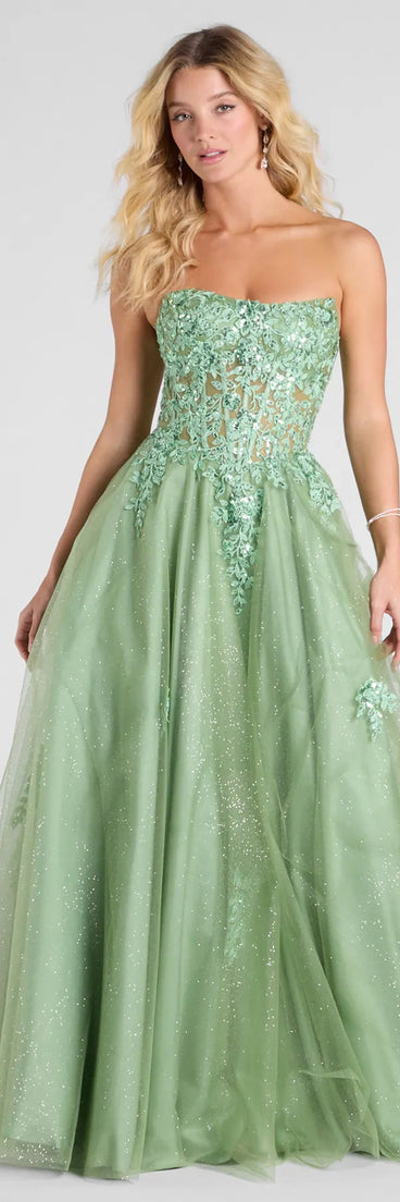 The Petra Sequin Floral Applique Glitter Tulle Gown in sage is a stunning green prom dress designed to capture attention with its fresh or bold color and effortlessly stylish silhouette.