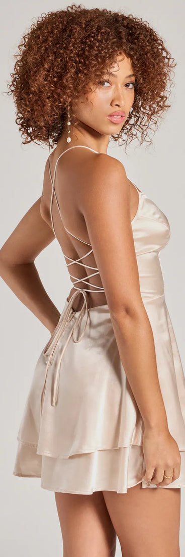 The Captivating Charm Sleeveless Satin Tiered Skater Dress is a mini dress in gold, perfect for an above-the-knee holiday party dress or a stylish NYE look, with a short hemline designed to make a winter statement.