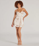 The Captivating Charm Sleeveless Satin Tiered Skater Dress is a stunning gold mini dress with a short hem, designed to be the perfect winter cocktail dress or night-out look for the holiday season.