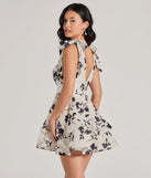 The Chantel Bow Tie V-Neck Floral Ruffle Skater Dress is a mini dress in ivory, perfect for an above-the-knee holiday party dress or a stylish NYE look, with a short hemline designed to make a winter statement.