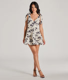 The Chantel Bow Tie V-Neck Floral Ruffle Skater Dress is a stunning ivory mini dress with a short hem, designed to be the perfect winter cocktail dress or night-out look for the holiday season.