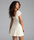 The Romantic Allure Flutter Sleeve A-Line Lace Mini Dress in ivory brings sleek style to any graduation outfit, from cap and gown to after-party.