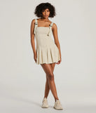 The Babe With Taste Buckle Strap Pleated Mini Dress is a stunning taupe mini dress with a short hem, designed to be the perfect winter cocktail dress or night-out look for the holiday season.