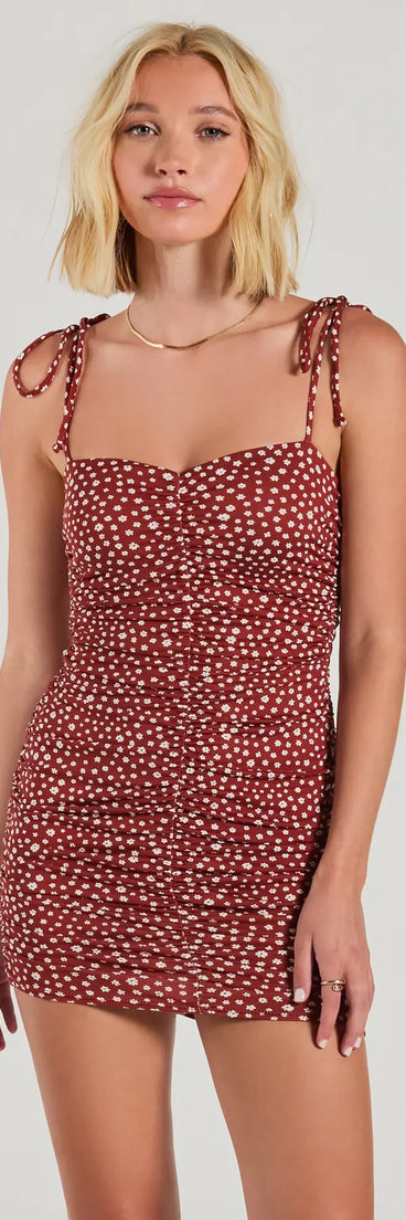 Step into winter chic with the Fun And Games Tie Strap Bodycon Floral Mini Dress, a raisin purple mini dress featuring an above-the-knee cut ideal for cocktail parties, festive gatherings, or clubwear.