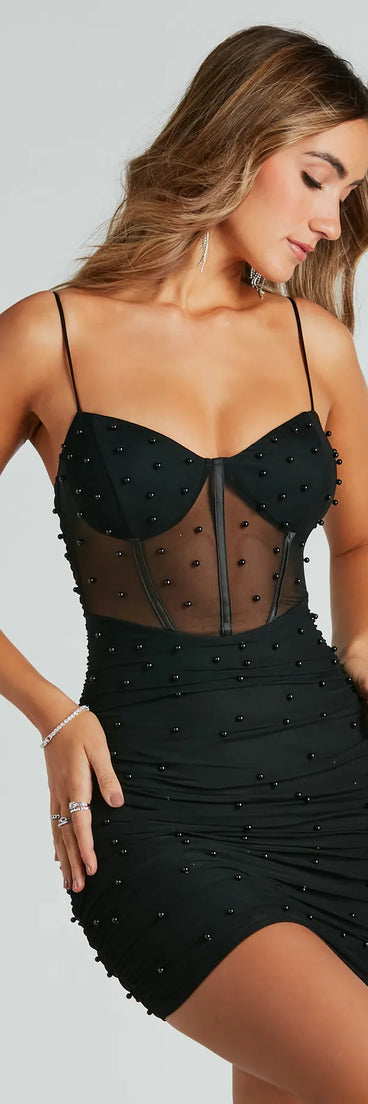 Step into winter chic with the Sassy But Classy Faux Pearl Bustier Mini Dress, a black mini dress featuring an above-the-knee cut ideal for cocktail parties, festive gatherings, or clubwear.
