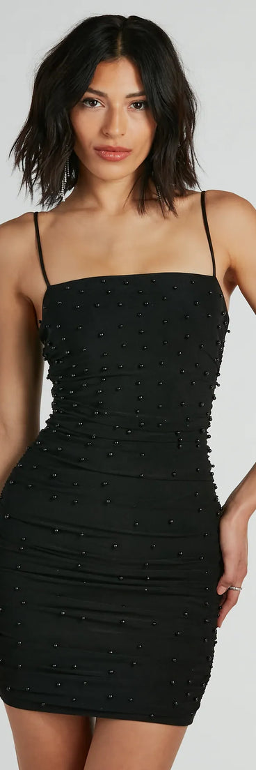 Step into seasonal chic with the Extra Chic Pearl Ruched Mesh Mini Dress, a black mini dress featuring an above-the-knee cut ideal for cocktail parties, festive gatherings, or clubwear.