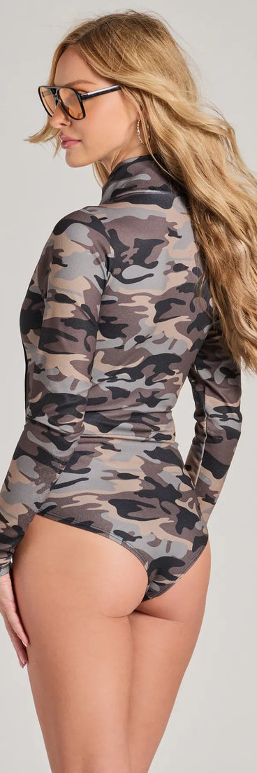 The Sultry Soldier Camo Long Sleeve Bodysuit is a women's multi-color long-sleeve top with festive style and unique design accents, perfect for layering during the holiday season or transitioning into colder months.