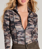 The Sultry Soldier Camo Long Sleeve Bodysuit is a women's multi-color long-sleeve top with festive style and unique design accents, perfect for layering during the holiday season or transitioning into colder months.