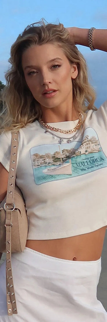 Add a summer refresh to your look with the Greetings From Mallorca Graphic Tee, a trendy top in white made for easy styling for any vibe.