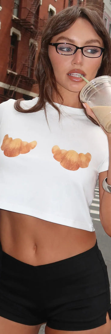 For college campus looks, game day outfits, or a bold going-out vibe, the Baked Goods Croissant Graphic Tee is an on-trend white crop top that easily styles with your favorite denim.