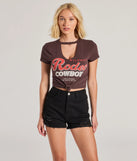 The Rodeo Cowboy Cutout Crop Graphic Tee in brown with a modern design and trendy look is part of the latest women's tops collection to elevate your 2025 wardrobe.