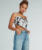 Country Chick Cow Print Satin Crop Top, a trendy white addition to women's going-out outfits, is ideal for Christmas party outfits, chic NYE attire, or winter night-out looks that keep you on-trend!