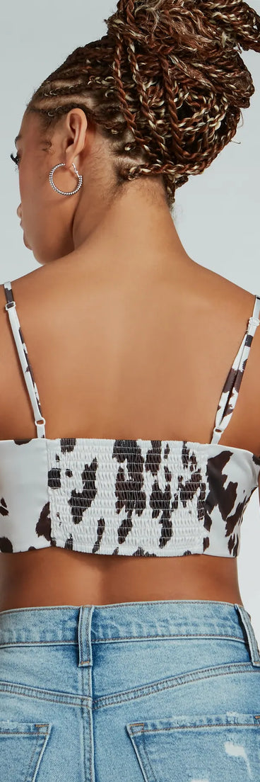 Country Chick Cow Print Satin Crop Top, a trendy white addition to women's going-out outfits, is ideal for Christmas party outfits, chic NYE attire, or winter night-out looks that keep you on-trend!