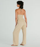 The Coastal Cutie Halter Cutout Striped Linen Jumpsuit in taupe is a versatile women's jumpsuit with trendy design accents, crafted for holiday-ready looks, from office wear to sophisticated winter night outs.