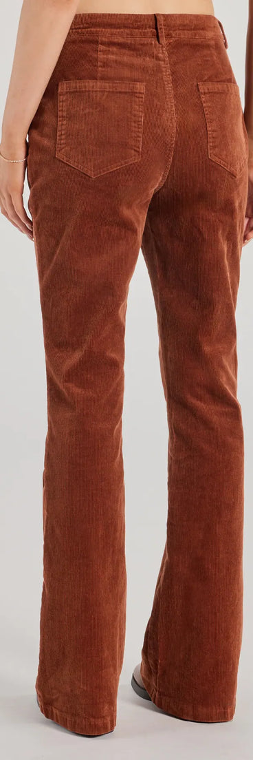 The Retro Chic Corduroy High-Rise Flare Pants is a trendy women's bottom in rust, designed with modern details and alluring textures to complete chic outfits for 2025.