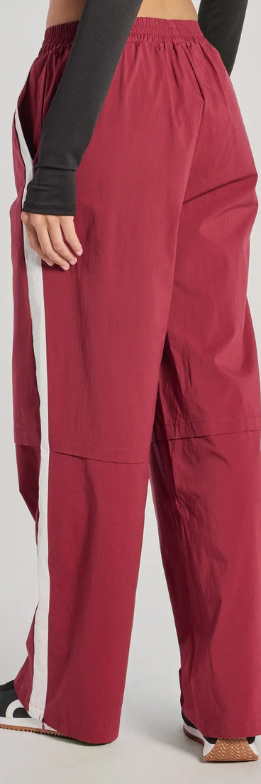 The Star Of The Track High-Rise Striped Track Pants is a trendy women's bottom in burgundy, designed with modern details and alluring textures to complete chic outfits for 2025.