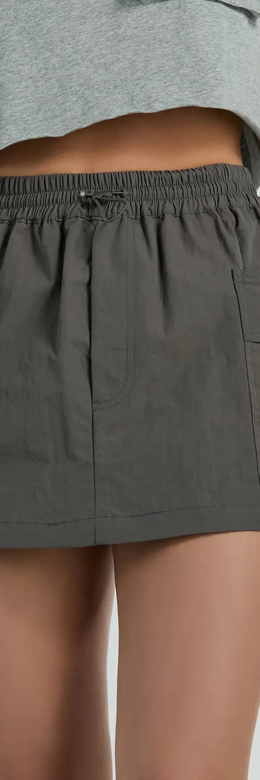 The Taking Flight Cargo Mini Skort is a trendy women's bottom in charcoal, designed with modern details and alluring textures to complete chic outfits for 2025.