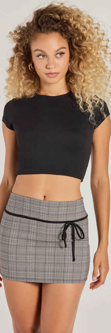The Posh Cutie Bow Trim Plaid Mini Skirt in black is a women's workwear essential with an elevated fabric and chic silhouette, ideal for layering and versatile enough to take your look from office chic to going-out ready!