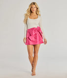 The Adorable Muse Bow Detail Mini Skirt is a trendy women's bottom in fuchsia, designed with modern details and alluring textures to complete chic outfits for 2025.