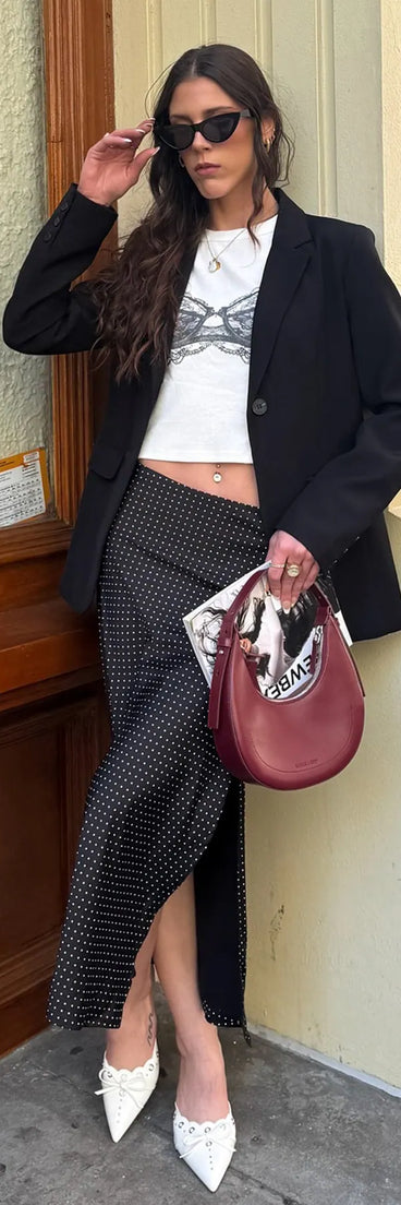 Choosing the black skirt says you’re ready to show off in the There She Goes High-Rise Slit Polka Dot Satin Midi Skirt, a warm-weather staple that elevates your outfit and seasonal style.