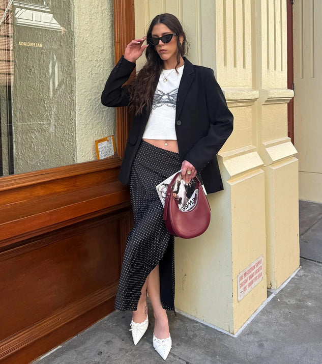 Choosing the black skirt says you’re ready to show off in the There She Goes High-Rise Slit Polka Dot Satin Midi Skirt, a warm-weather staple that elevates your outfit and seasonal style.