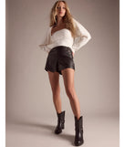 The On The Edge High Rise Belted Faux Leather Skort is a trendy women's bottom in black, designed with modern details and alluring textures to complete chic outfits for 2025.