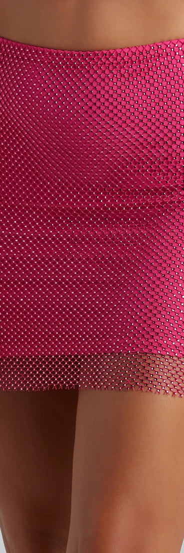 The Party Mood Rhinestone Sheer Fishnet Mini Skirt in fuchsia features a short, flattering cut designed to elevate your look with just the right amount of edge.