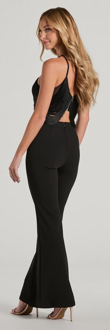 The Step Up Draped Fringe Halter Cutout Jumpsuit in black is a versatile women's jumpsuit with trendy design accents, crafted for holiday-ready looks, from office wear to sophisticated winter night outs.