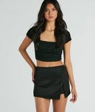 The Significant Strut Mid-Rise Bow Slit Skort is a trendy women's bottom in black, designed with modern details and alluring textures to complete chic outfits for 2025.