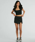 The Significant Strut Mid-Rise Bow Slit Skort is a trendy women's bottom in black, designed with modern details and alluring textures to complete chic outfits for 2025.