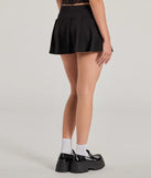 The Style Game High-Rise Buckle Pleated Mini Skort is a trendy women's bottom in black, designed with modern details and alluring textures to complete chic outfits for 2025.