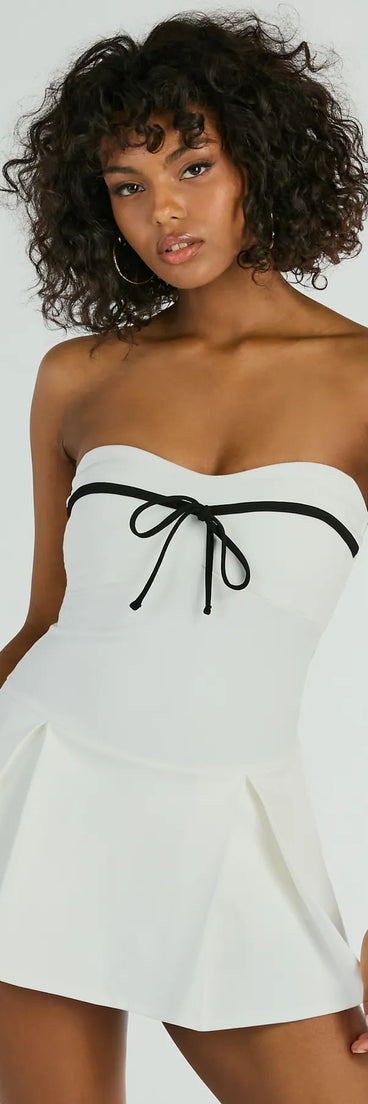 Elevate your winter wardrobe with the Sweet Muse Strapless Bow-Detail Skater Romper— a party-ready ivory cocktail dress featuring seasonal accents and a sophisticated style, ideal for semi-formal holiday events from family dinners to NYE celebrations.