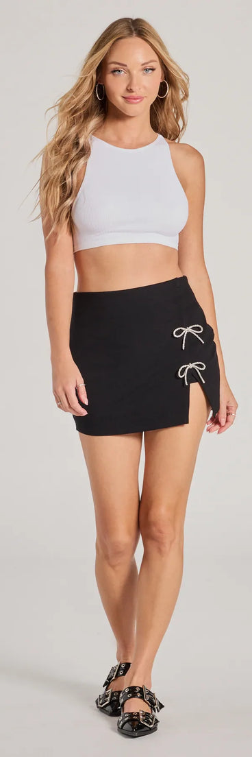 The Exceptionally Precious Rhinestone Bow Ponte Skort is a trendy women's bottom in black, designed with modern details and alluring textures to complete chic outfits for 2025.